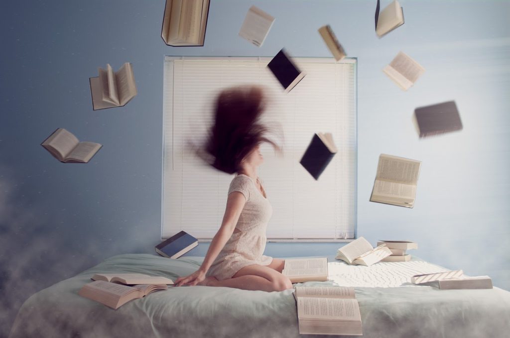 A translator surrounded by books on a bed