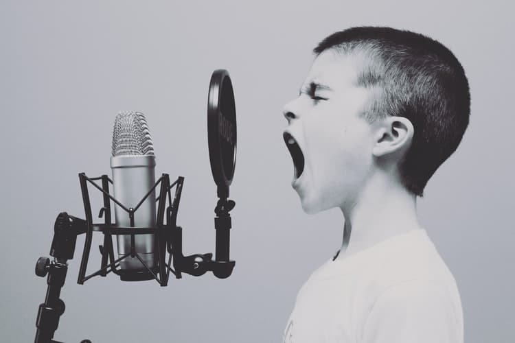 photo of a boy shouting into a microphone