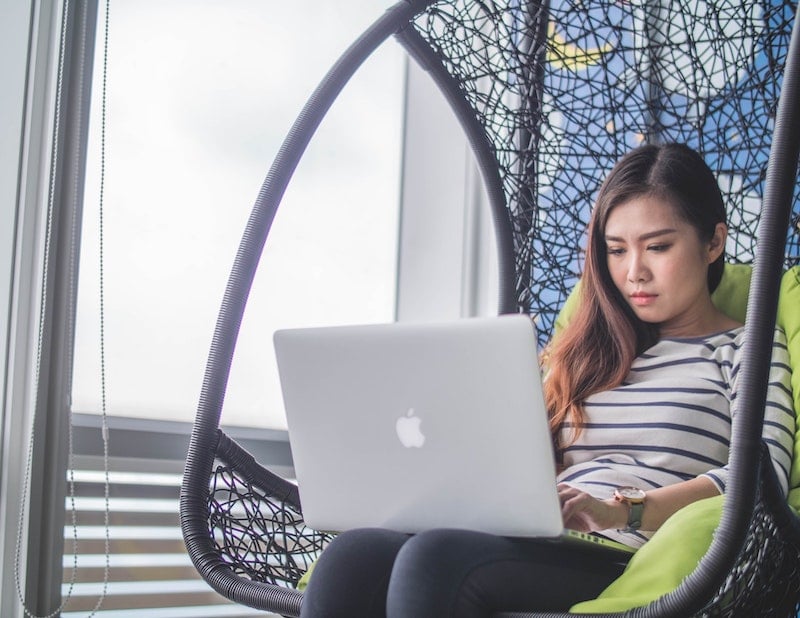 Woman working with a laptop, trying to manage her calendar