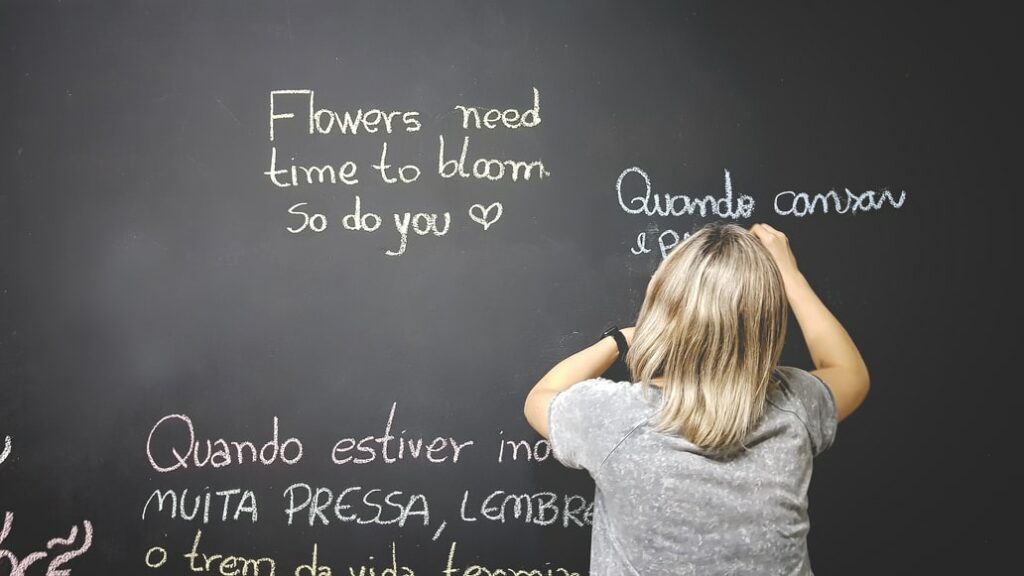 A women writing on a blackboard in different languages