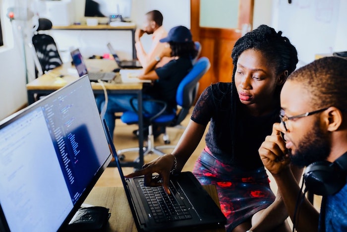 Two people working on a multilingual localization SEO strategy in front of two screens in an office