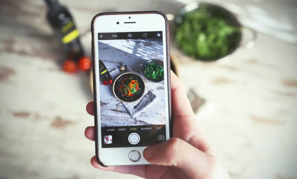 Taking a photo of food on a cellphone to share on social media