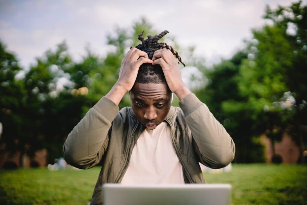 A stressed man is looking at his computer looking for hreflang tag errors