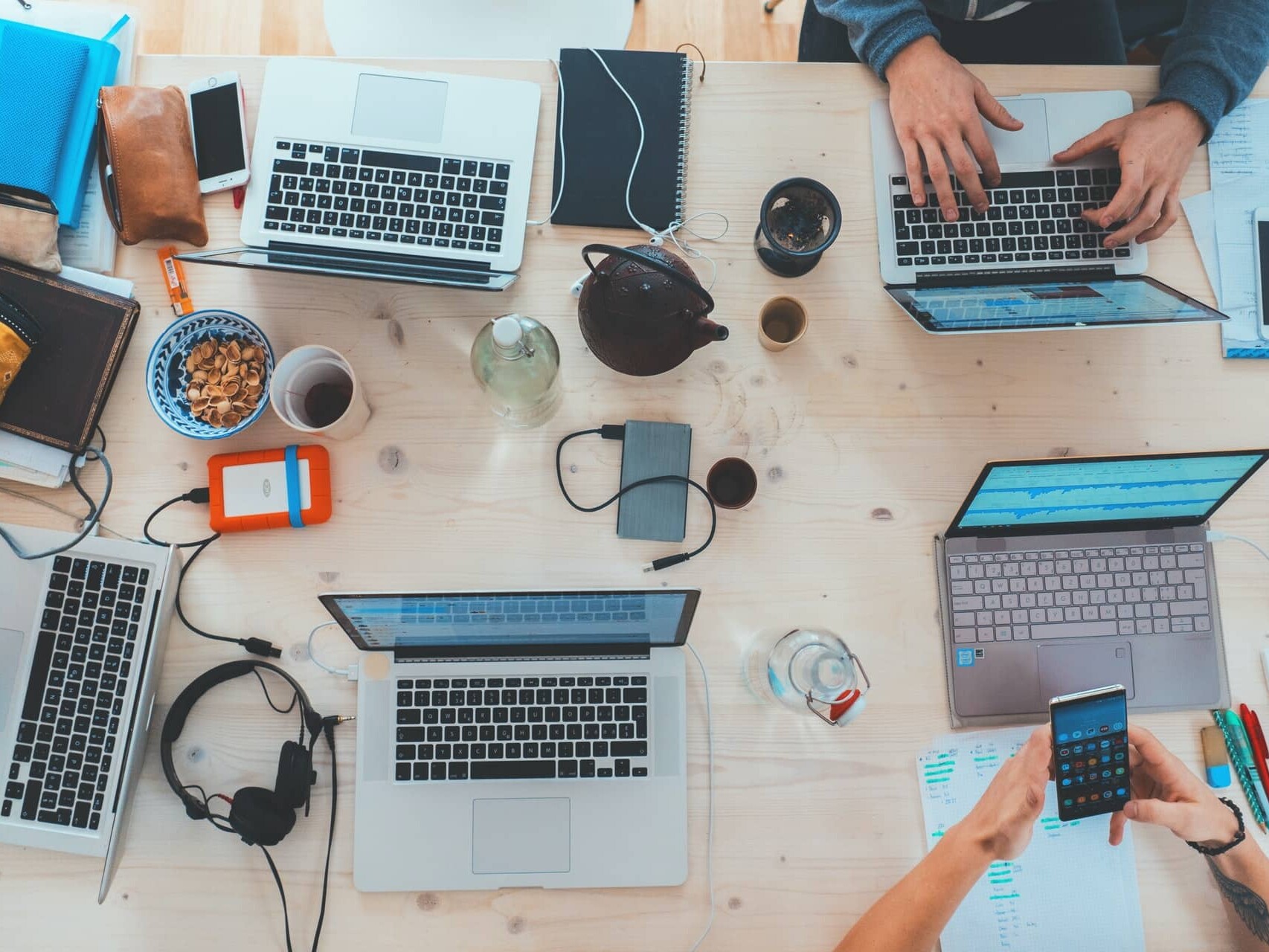 A team working on laptops at one large table