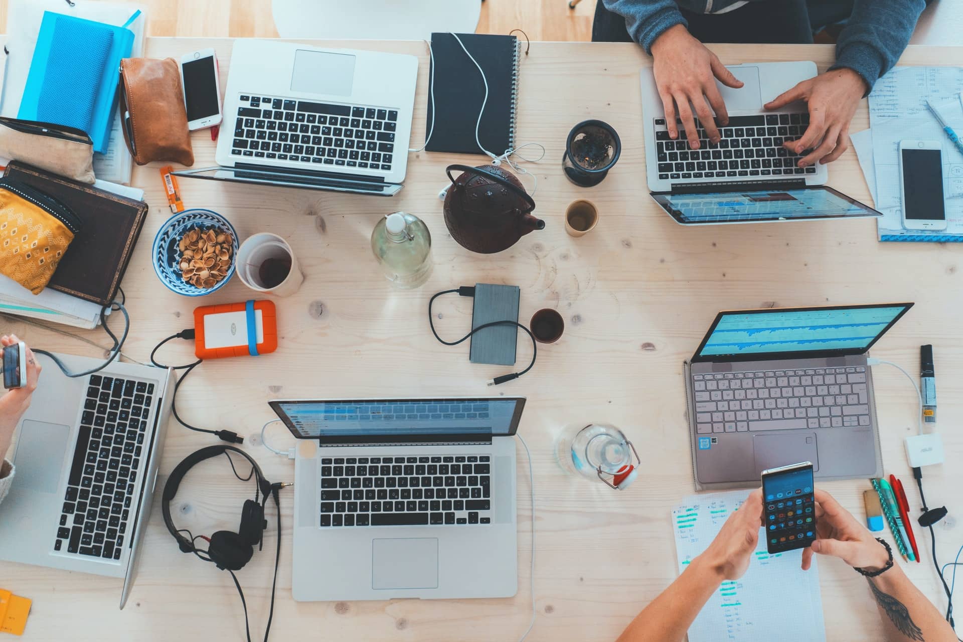 A team working on laptops at one large table