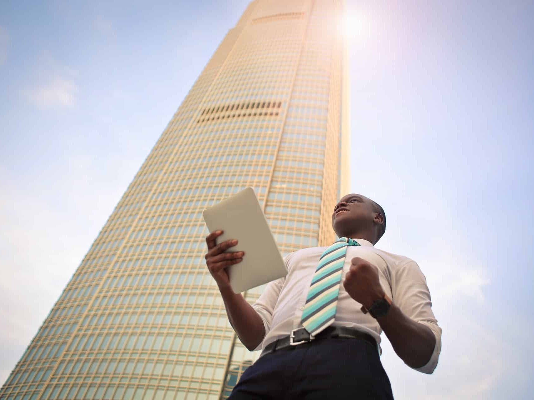 Skyscraper and a man holding tablet representing EMEA marketing