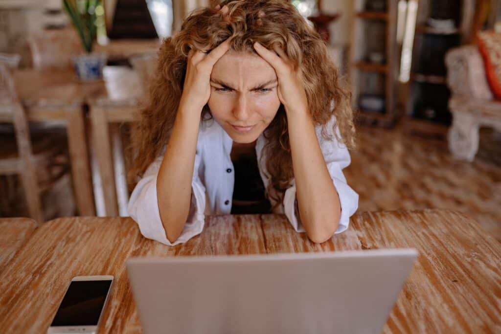 Woman looking upset at a computer because the website is poorly translated