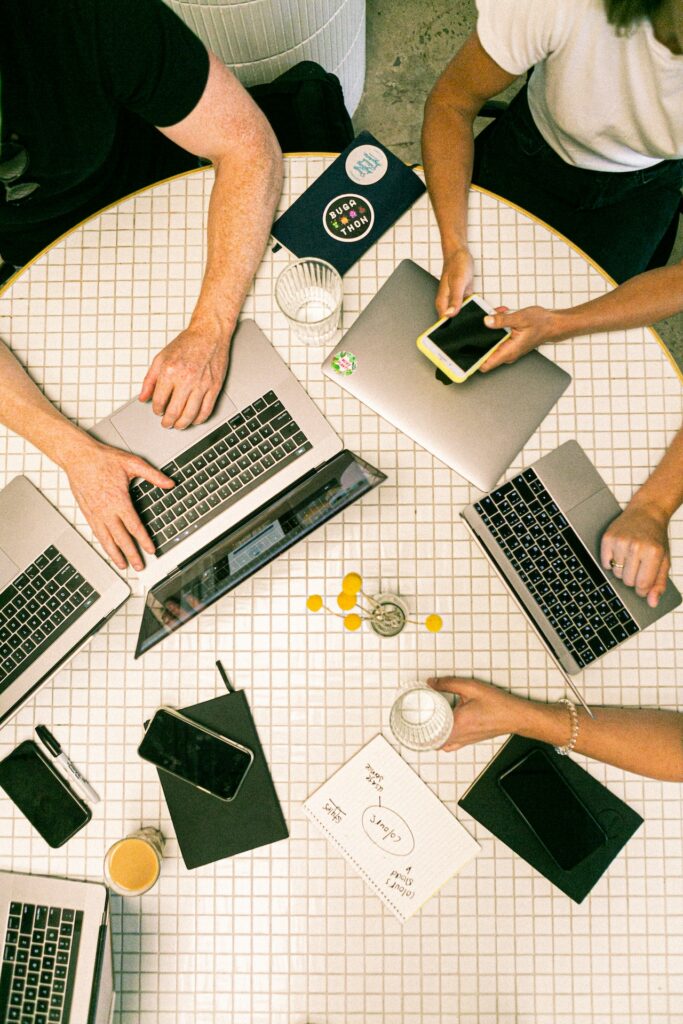 A group of marketers around a table with laptops discussing multilingual marketing