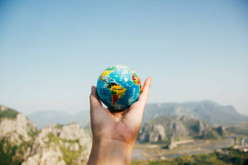 Person holding a small globe in their hands