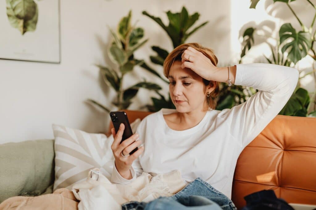 A woman looking at her phone confused by a poorly translated social media post