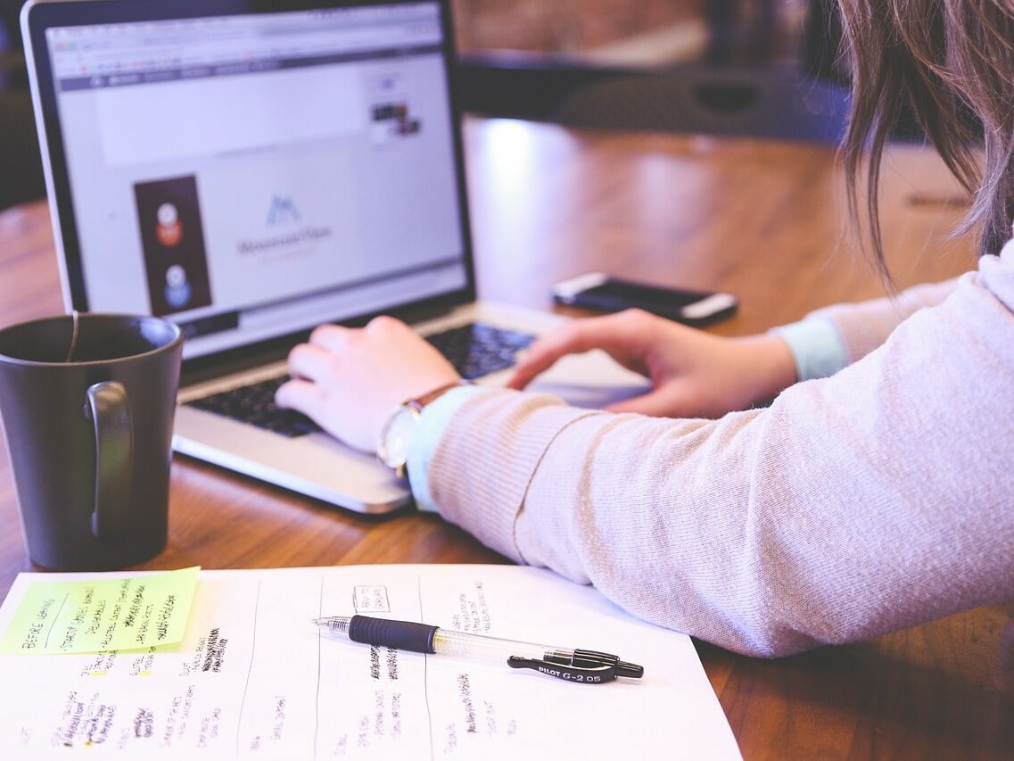 Person typing on laptop while working on a multilingual social media strategy