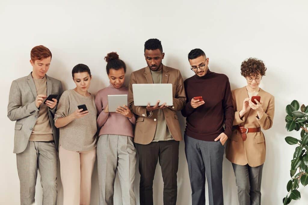 Several people checking their email on their phones or laptops