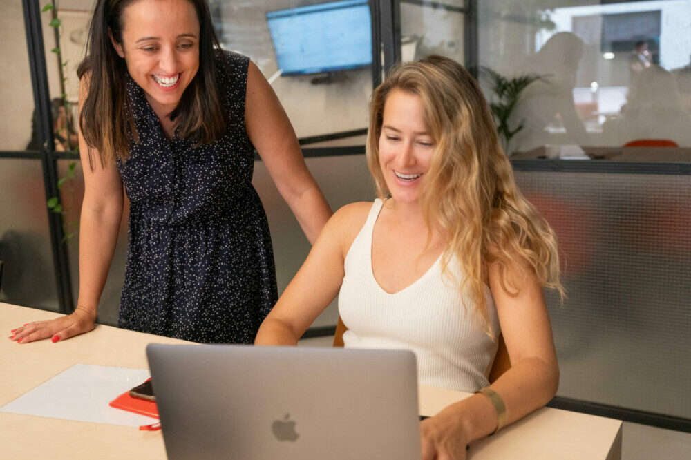 VeraContent team members looking at translation management software on laptop