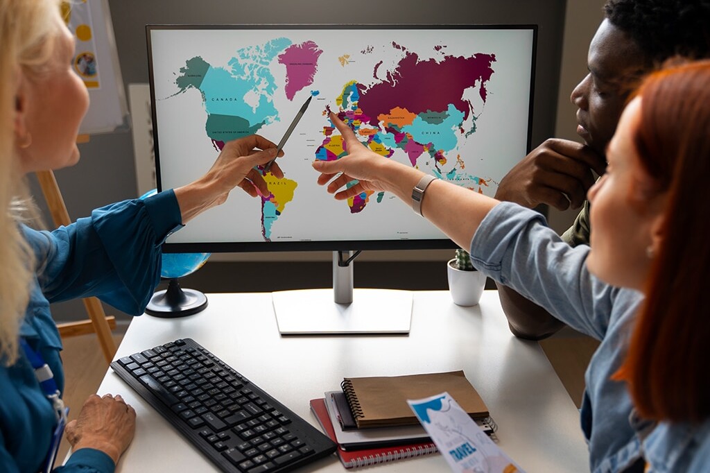 coworkers pointing to world map while discussing local marketing for global brands