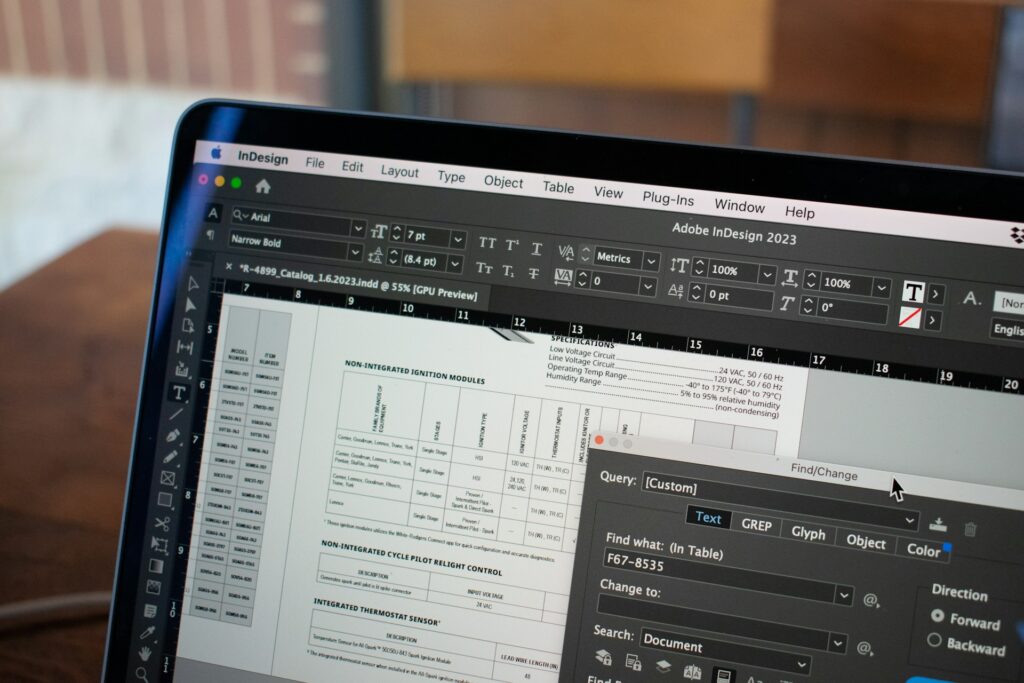 This close-up image showcases a MacBook Pro screen displaying an open project in Adobe InDesign