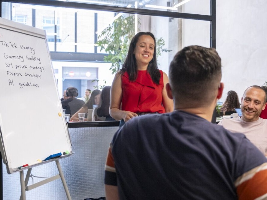 VeraContent team members sitting around a table with a whitepaper board