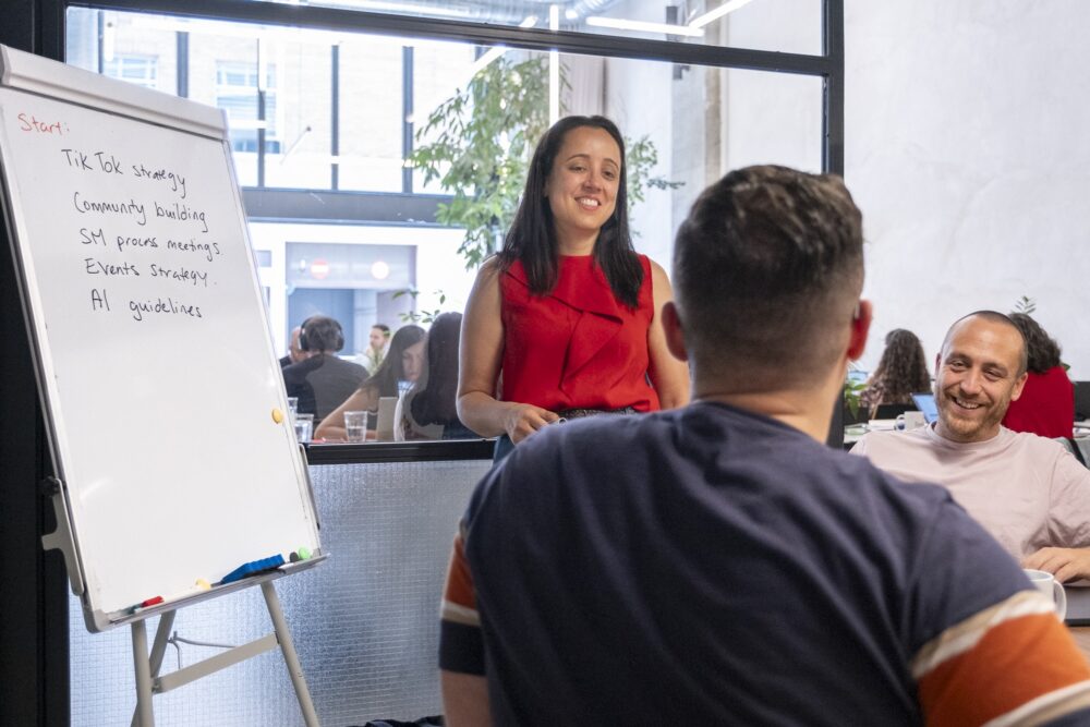 VeraContent team members sitting around a table with a whitepaper board