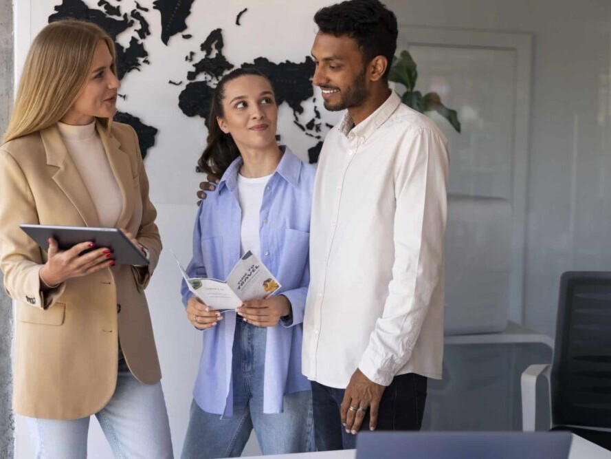 Three designers standing discussing how to translate inDesign files
