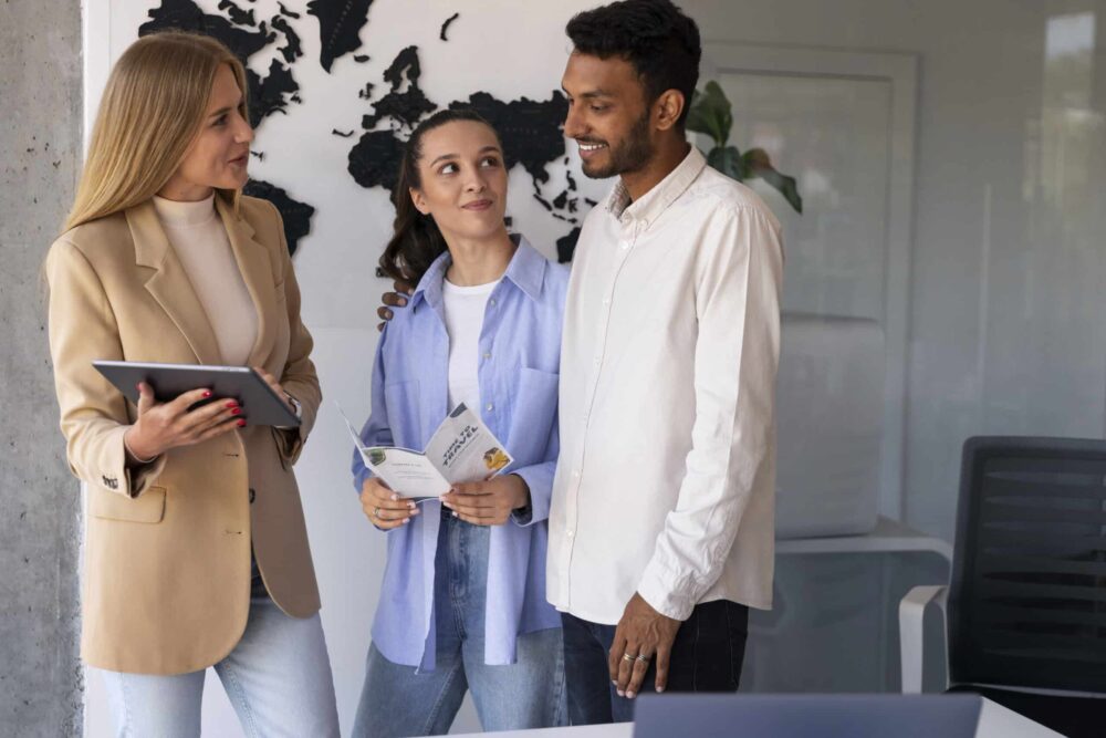 Three designers standing discussing how to translate inDesign files