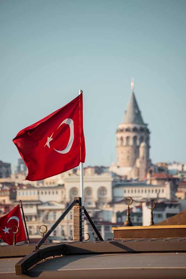 two flags flying in front of a city skyline in Istanbul, Turkey