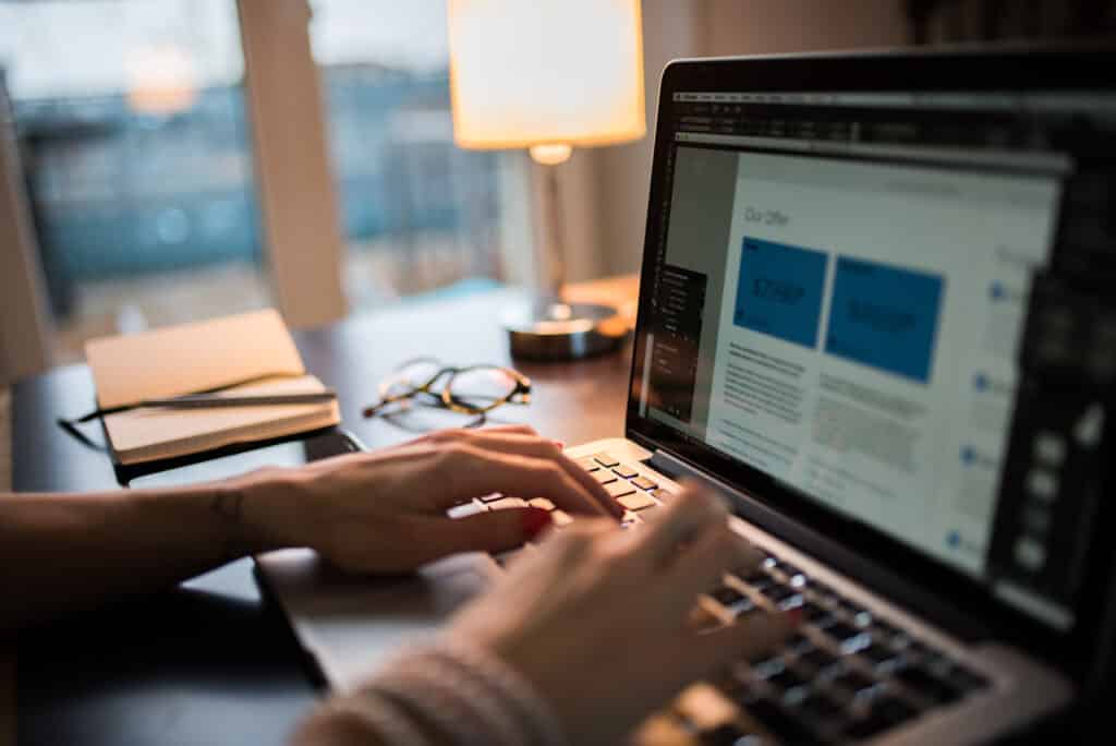An image showing a laptop with persons hands typing while creating a multilingual blog strategy