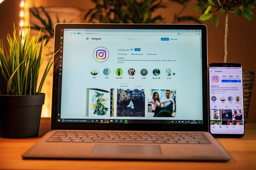 A laptop and cellphone both showing the same Instagram profile on the screen
