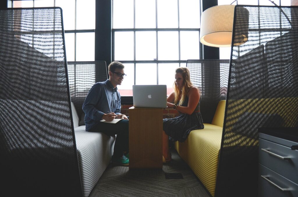 Two coworkers sitting in a booth working on a multilingual SEO campaign