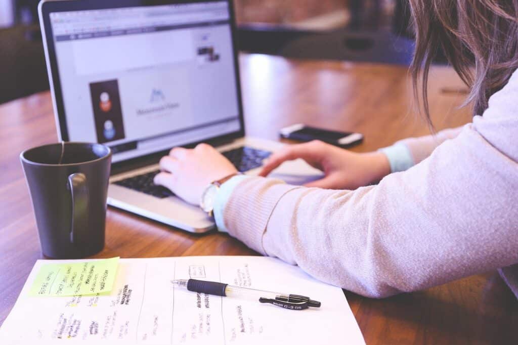 Person typing on laptop while working on a multilingual social media strategy