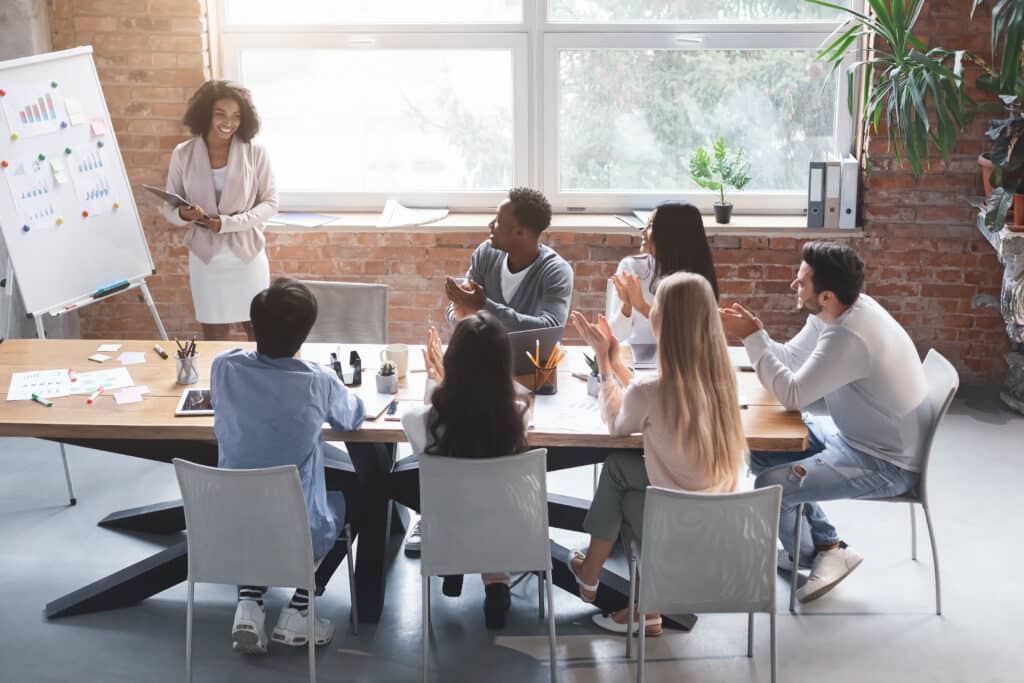 Woman making international content marketing presentation to young international business team