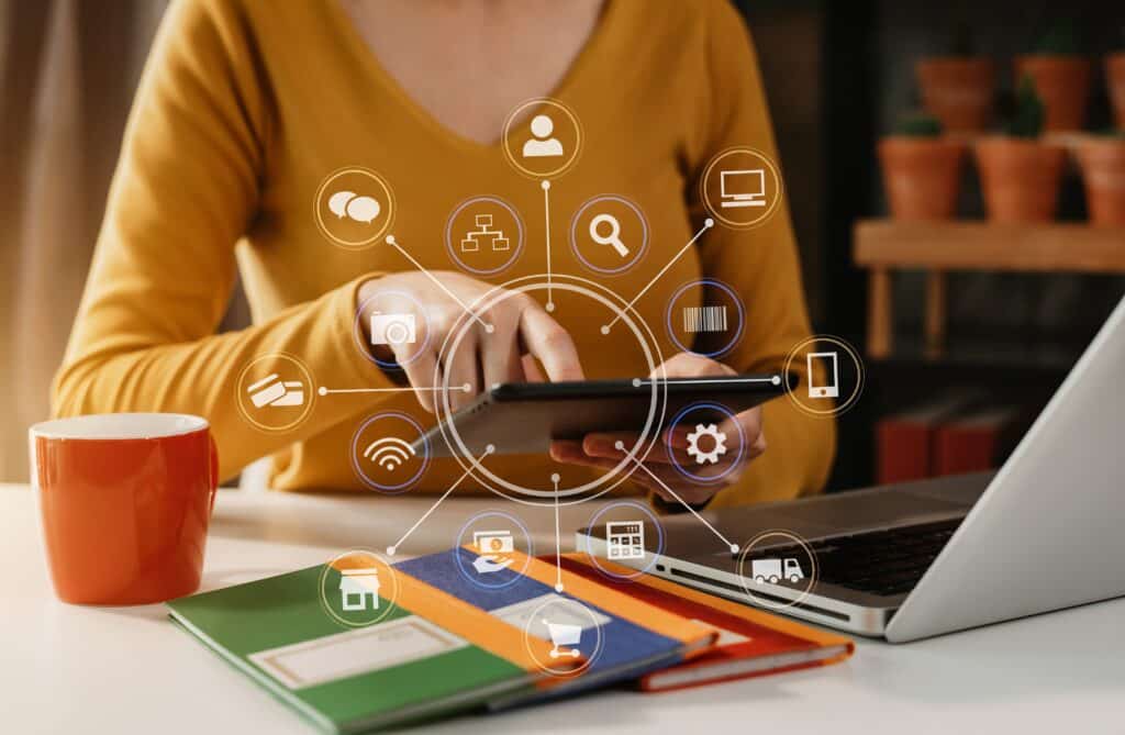 Social media and multilingual marketing campaigns virtual icons screen of business women typing keyboard with laptop computer and tablet at office.