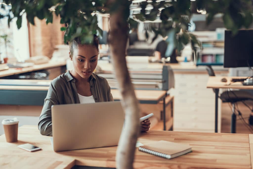 Localization tester working on laptop with a tree in the foreground
