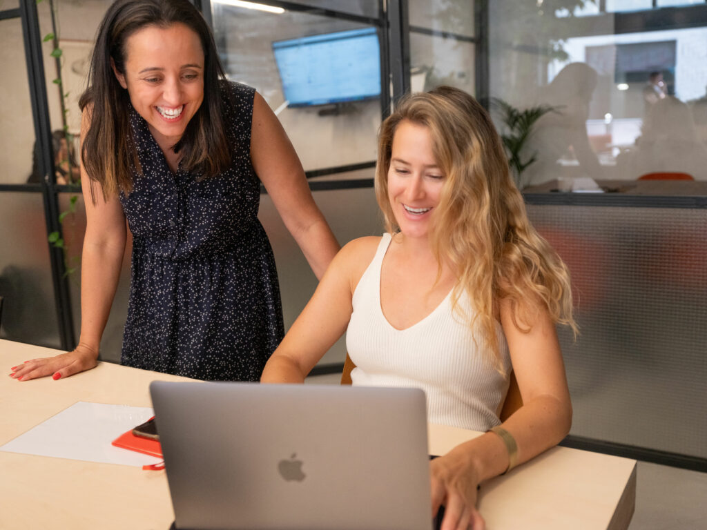VeraContent team members looking at translation management software on laptop