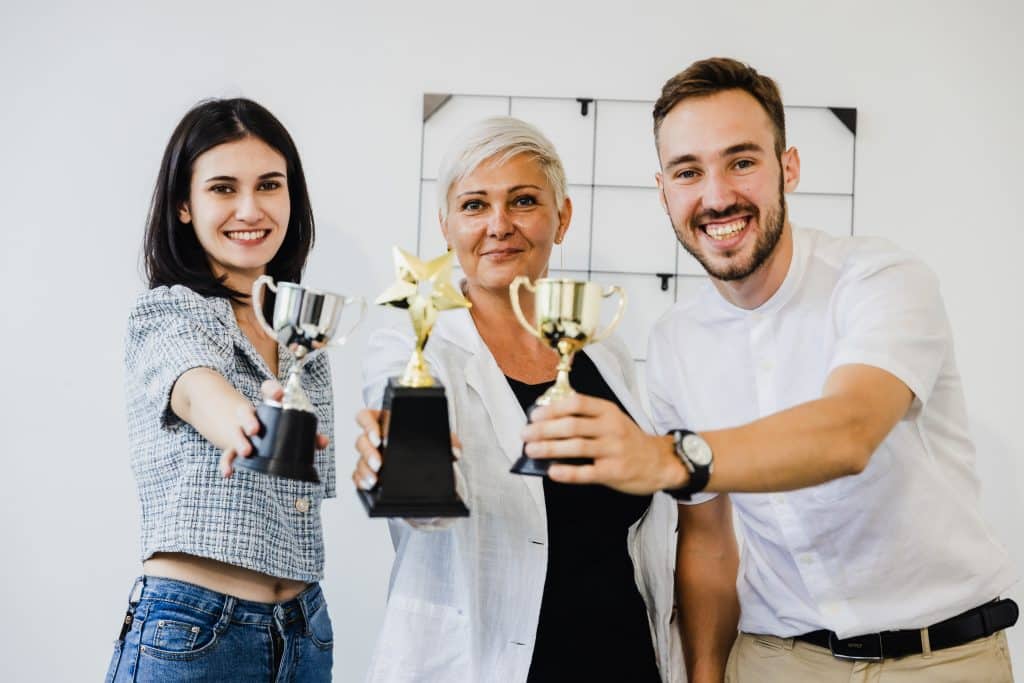 Businessman team holding award trophy for show their victory.