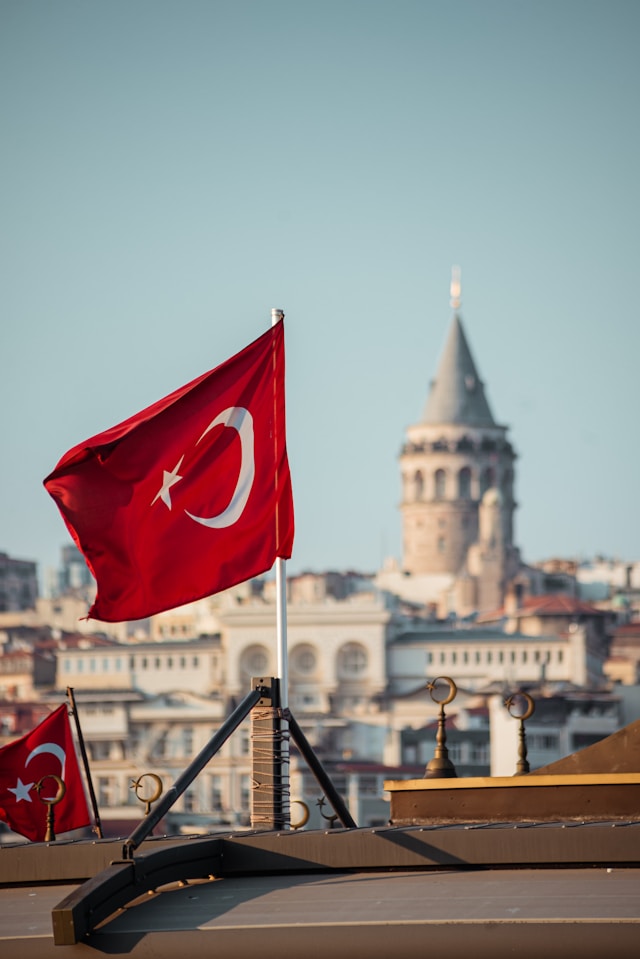 Two flags flying in front of a city skyline in Istanbul, Turkey