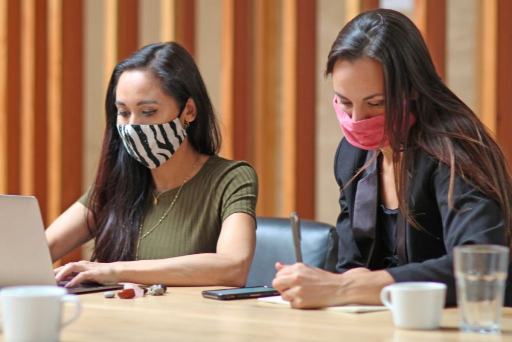 Two women taking notes on social movements and global events